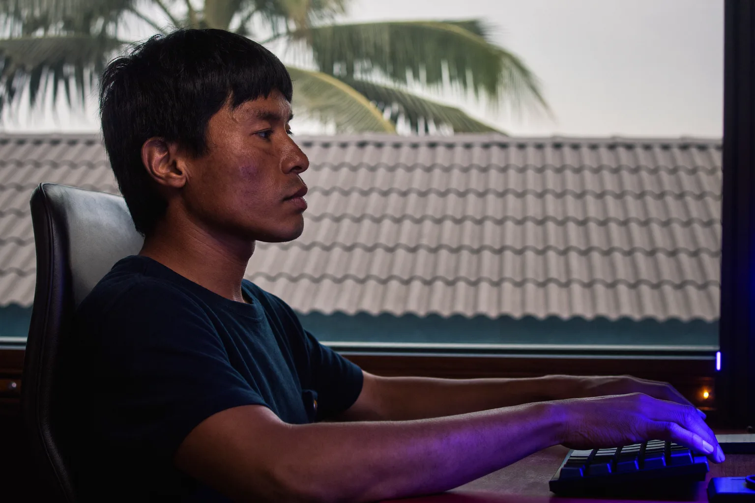 Isang tao na nakikita mula sa gilid, nakaupo sa desk na patag ang mga paa sa sahig, nakasandal ang likod sa upuan, kapantay ng desk ang mga braso, at nasa antas ng mata ang monitor, ang tamang reference posture sa desk