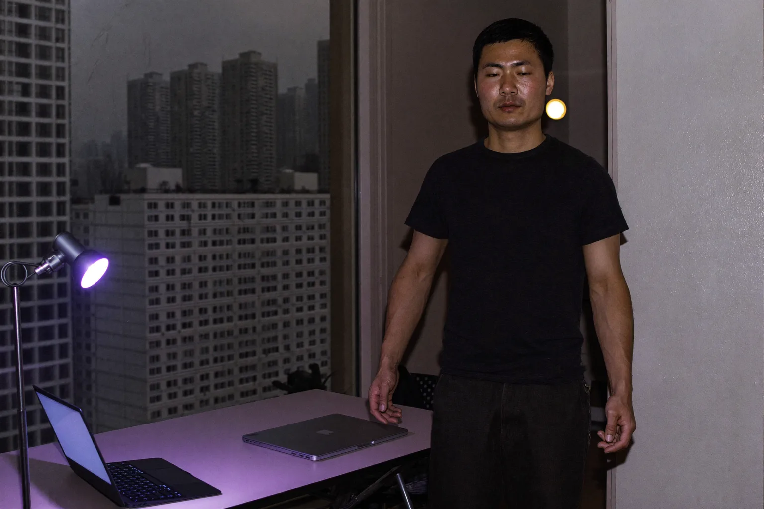 傍晚時分，家中書桌上闔起的筆電，房間的燈還亮著，一個人正轉身離開，象徵遠距工作一天的結束